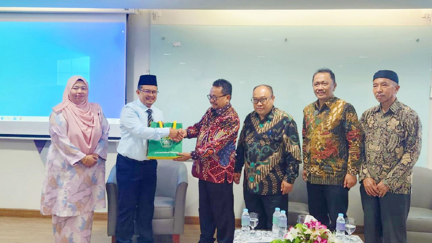 direktur menyerahkan oleh-oleh dari indonesia setelah presentasi di UiTM Malaysia